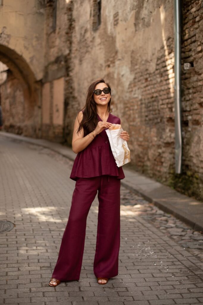 mergina dėvi bordinį lininį elegantišką kostiumėlį senamiestyje